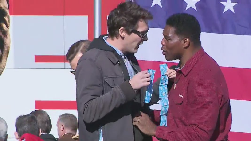 Herschel Walker rallies in Macon, person approaches senate candidate after rally
