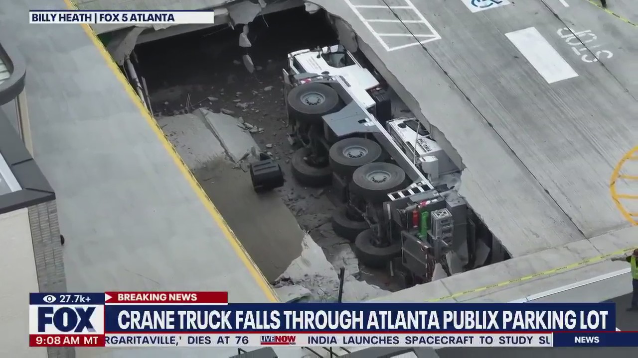 Crane truck falls through Publix parking lot