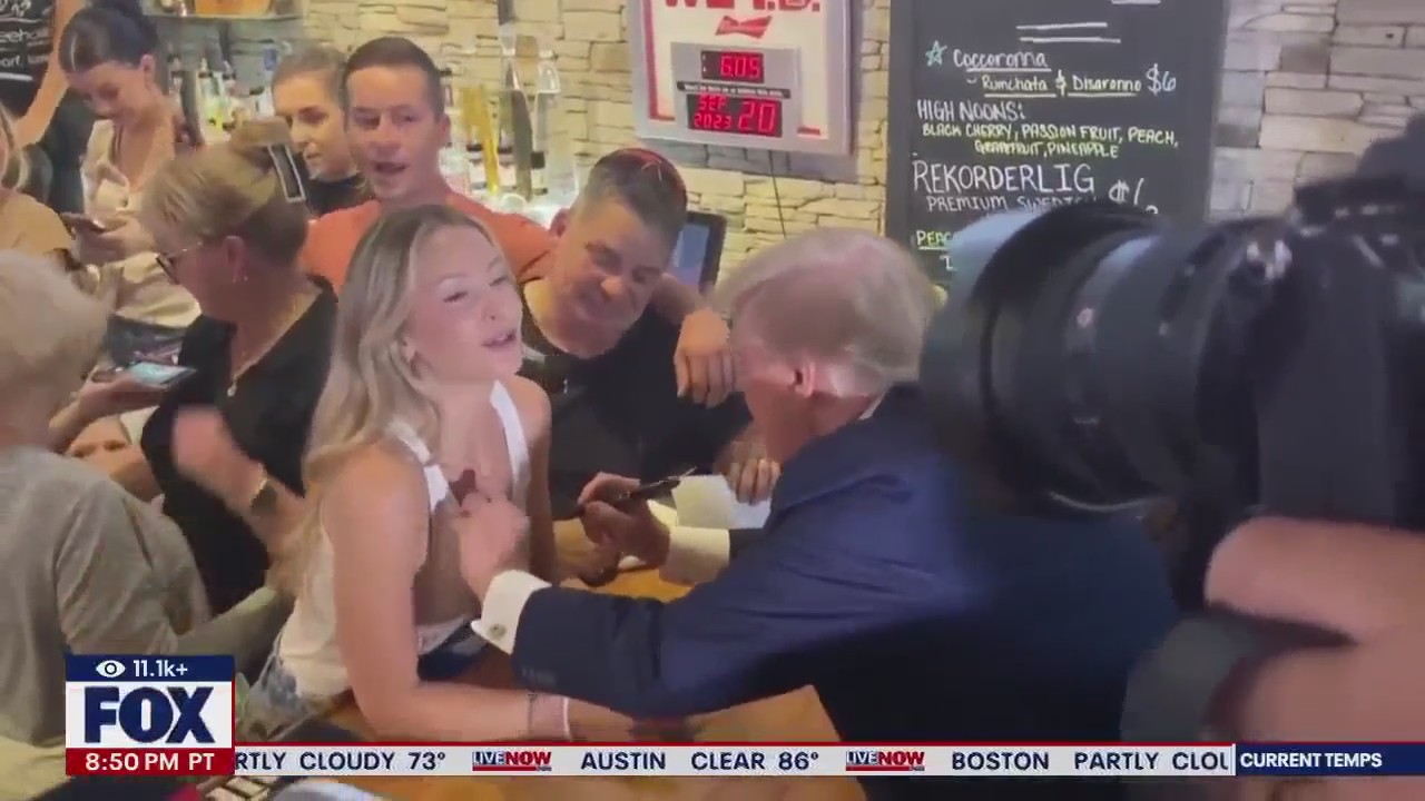 Trump autographs woman's tank-top in Iowa