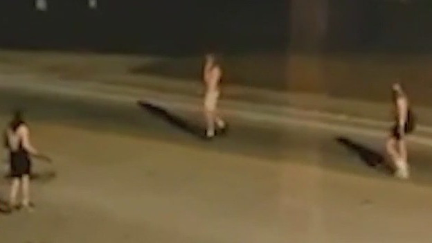 Men throwing metal rods at moving cars