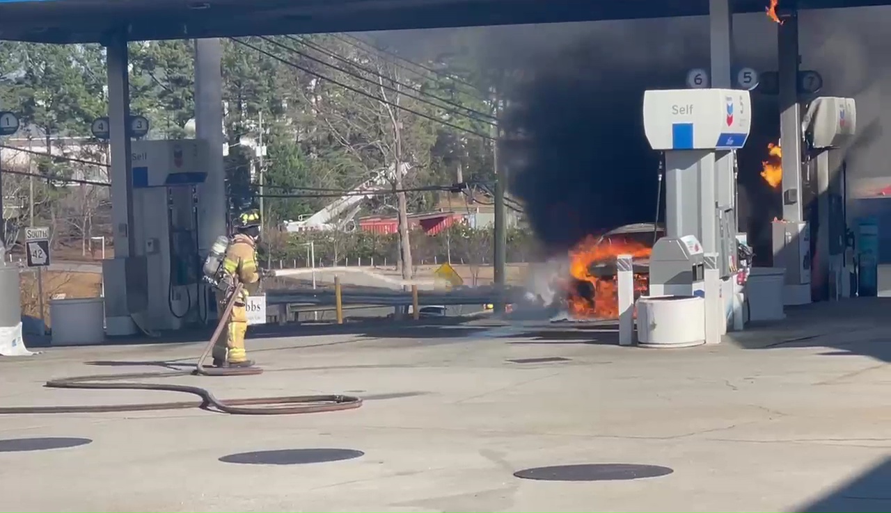 Crew rushes to put out gas station car fire