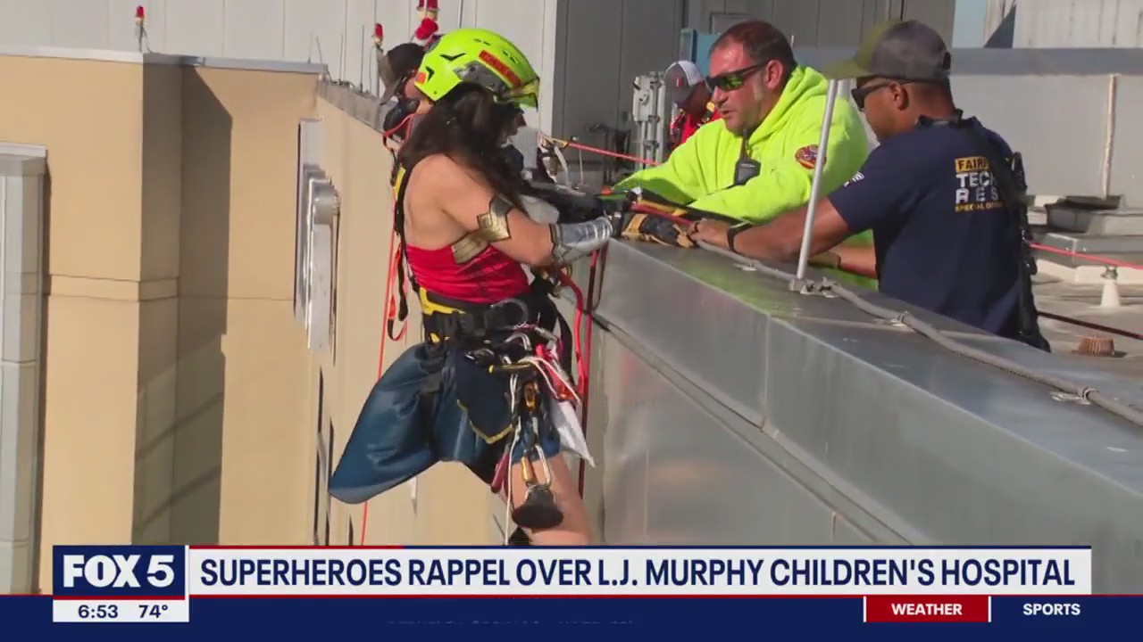 Superheroes rappel over children's hospital