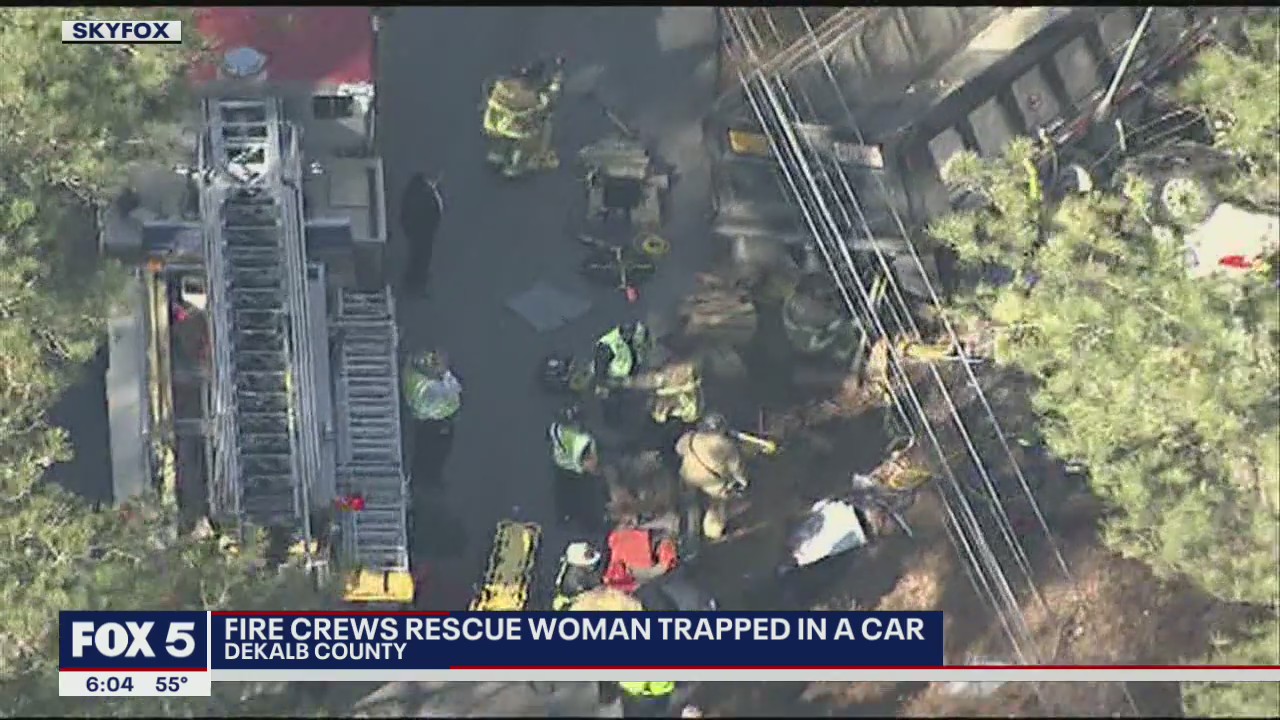 Fire crews rescue woman trapped in car pinned under dump truck